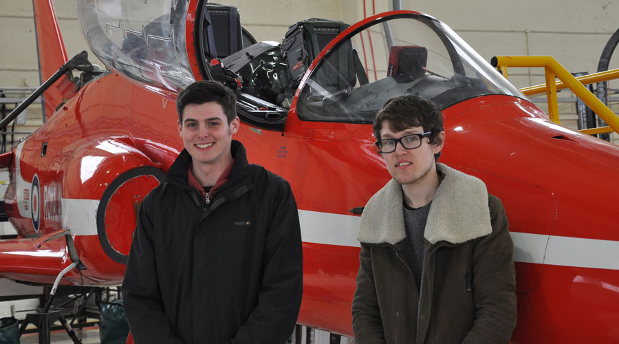 Apprentices Dan Higby and Ashley Filby in front of a Red Arrows Hawk at RAF Scampton 