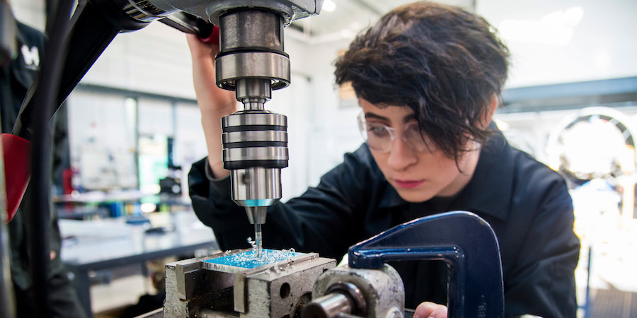 Engineering student using drilling machine